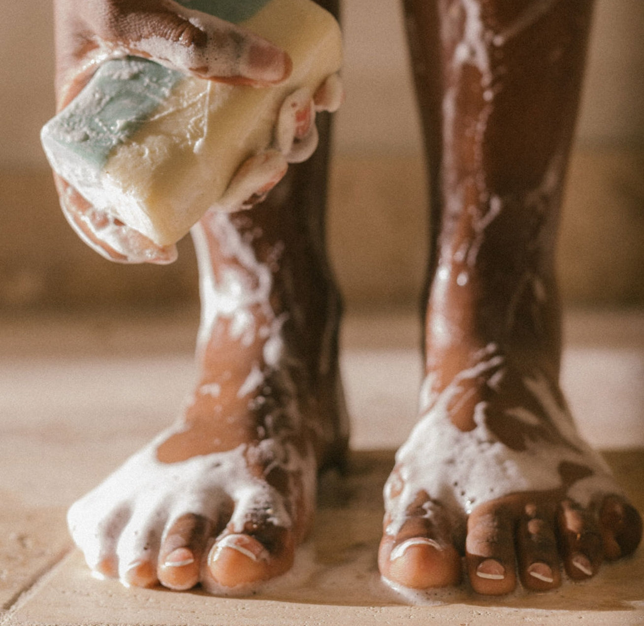 Elegant Black woman lathering Oshun goat milk soap in the shower—luxury, clean skincare that’s gentle and nourishing.
