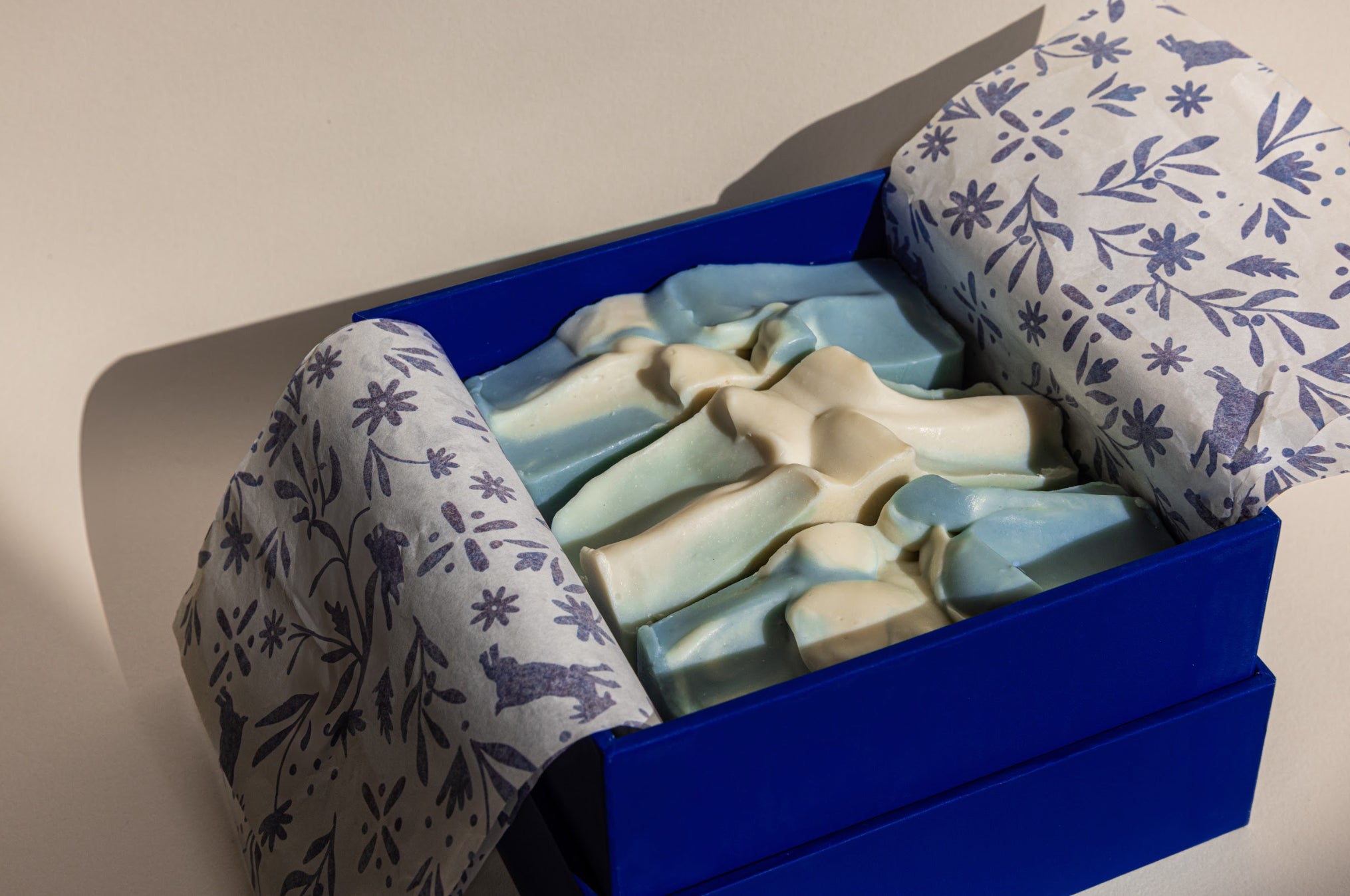 Oshun Society box with four unwrapped goat milk soap bars—luxury, fragrance-free skincare delivered quarterly.