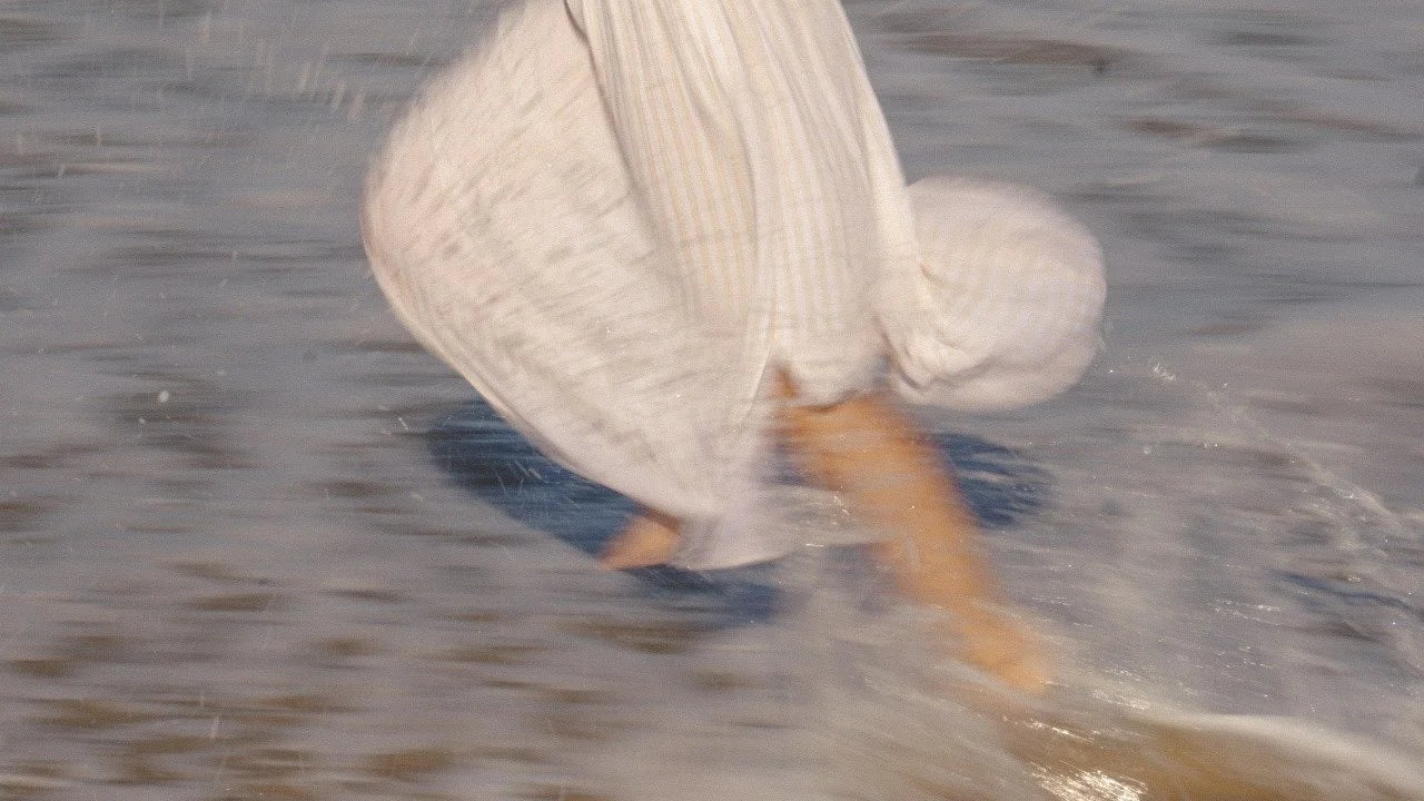 Flowing dress and bare feet of a woman running through ocean surf, symbolizing Oshun’s feminine, nature-inspired luxury skincare ritual.
